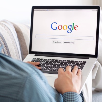 man sitting at the MacBook retina with site Google on the screen
